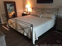 Three-quarter view of assembled bed frame showing headboard, footboard, side rails and mattress