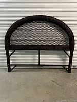 Front view of brown wicker rattan arched headboard with rails attached