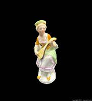Front view of hand-painted Victorian woman figurine holding mandolin