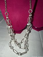 Necklace draped on bust showing bead and link detail