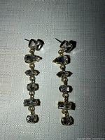 Front view of both gold-tone rhinestone dangle earrings