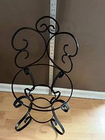 Full view of black wrought iron chair frame with scroll back and ring seat