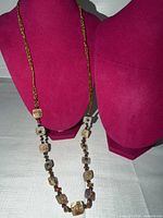 Full view of entire necklace draped on display busts