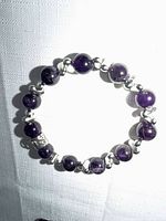 Full view of circular bracelet showing arrangement of amethyst and silver beads
