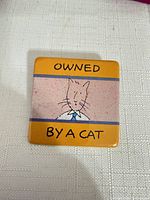 Front view of square pin showing design and text