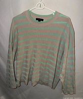 Front view of the striped long-sleeve sweater on hanger