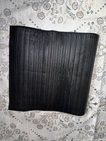 Top view of black ribbed rubber mat laid flat