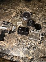 All components on tabletop: camera, housing, mount, battery, charger, memory card, adapter, spare panel