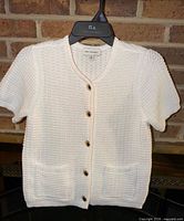 Full front view of sweater on hanger showing overall design