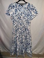 Full view of blue and white floral dress hanging