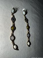 Both earrings full view on fabric backdrop