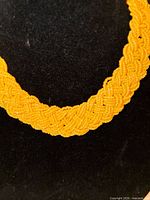 Full view of yellow braided seed bead choker on display bust