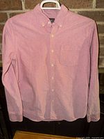 Front view of pink button-down shirt on hanger