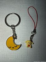 Crescent moon keychain and Pompompurin phone charm side by side