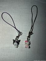 Both smartphone strap charms showing figures and straps