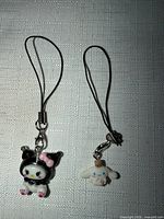 Front view of both Sanrio smartphone charms showing figures and straps