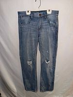 Full front view of jeans showing overall style and ripped knees