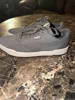 Side profile of both gray Puma skate sneakers showing uppers, midsoles and laces