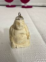 front view of carved Buddha pendant showing overall design