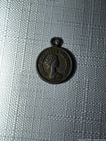 Front view of pendant showing bust and legend