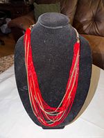 Front view showing red seed bead strands and gold-tone chains