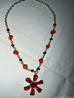 Full view of necklace laid flat showing chain, beads, pendant
