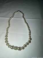 Full view of graduated pearl necklace forming oval