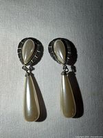 front view of both earrings showing pearl drops and silver frames