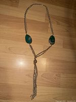 Full view of necklace laid flat showing Y shape, stones, multi-chain tassel