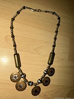 Full view of beaded choker necklace with five star charms displayed on surface