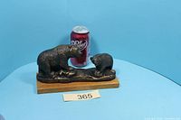 Front view of bronze-finish adult bear and cub sculpture with soda can for scale