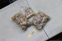 Three bags filled with wooden knobs on table