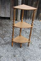 Full view three-tier wooden corner shelf, light brown wood