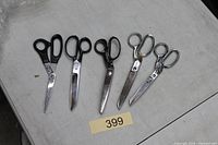 Six scissors laid out on table, blades closed