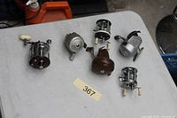 Six fishing reels arranged on tabletop