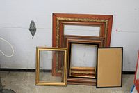 Five varied frames including ornate reddish wood and black-gold frame