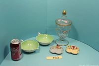 Full lot showing candy jar, two green dishes, two apple dishes, soda can for scale