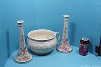 Chamber pot and two matching floral bases with soda can for scale