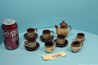 entire tea set with soda can for scale