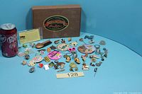 Full lot showing cigar box and spread of pins/buttons