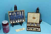 Both boxed spoon sets next to soda can for scale