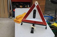 Warning triangle assembled on stand beside yellow case