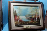 Framed oil painting on easel, entire artwork visible with frame