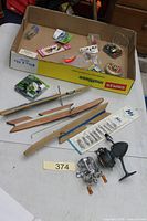 All items laid out including reels, tip-ups, lures, line, apron box visible