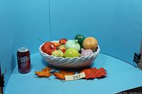 Full view of basket with all ceramic fruit, soda can for scale