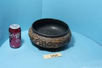 Side view with standard can for scale showing full bowl profile and relief design