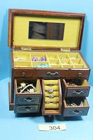 Overall view of wooden jewellery box open showing compartments, drawers and jewellery