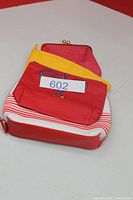 Stacked view of Shiseido pouch, rope motif pouch, and red coin purse