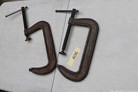 Two large C-clamps laid flat showing overall form