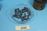 Overview of musket balls in glass dish with lot card
